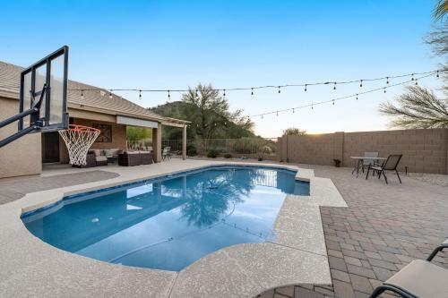 a swimming pool with a basketball hoop in a backyard at Hillview Haven in Mesa