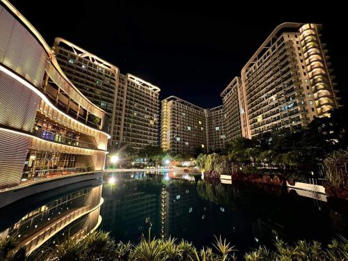 a view of a hotel at night with a pool at Azure Staycation Near the Airport in Manila