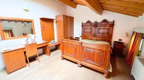uma casa de banho com uma grande cama de madeira num quarto em Possessioni Ferraresi em Melara