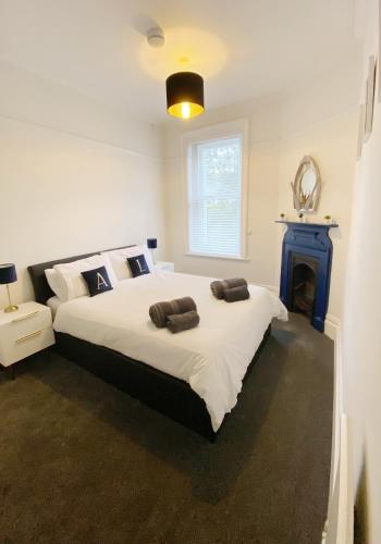 a bedroom with a large white bed and a fireplace at Sail Away Coastal Apartment Near Beach Parking Included Pet Friendly in Bournemouth