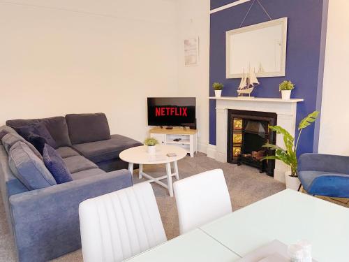 a living room with a couch and a fireplace at Sail Away Coastal Apartment Near Beach Parking Included Pet Friendly in Bournemouth
