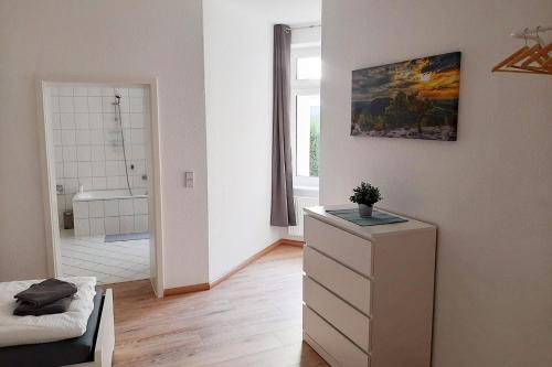 een slaapkamer met een dressoir en een badkamer met een bad bij Cozy 2 Room Apartment in Magdeburg in Maagdenburg