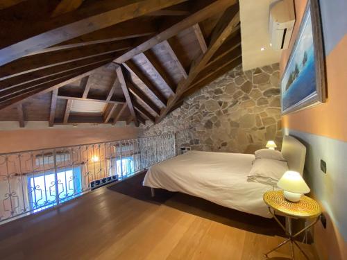 a bedroom with a bed and a stone wall at Bellavista in Feriolo in Baveno