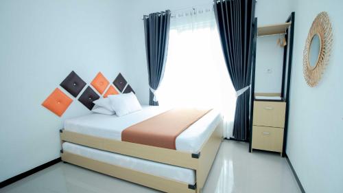 Un dormitorio con una cama con una ventana grande. en Villa Dewata with Chill Spot Private Pool and Karaoke, en Batu