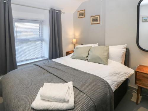a bedroom with a large bed and a window at 1 Dinas cottages in Caernarfon