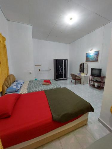 um quarto com uma cama vermelha e uma sala de estar em Rumah Rehat QNM Holidays em Kuala Terengganu