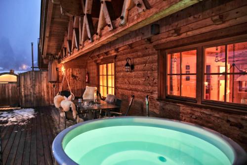 ein Badezimmer mit einer großen Badewanne in einem Holzgebäude in der Unterkunft Luxury Chalets Wiesenruh in Bichlbach
