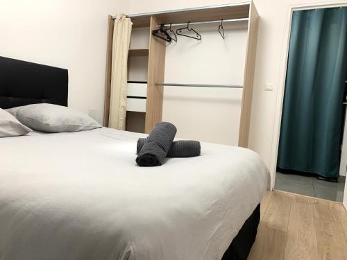 a bedroom with a bed with a gray towel on it at Appartement tout confort avec terrasse in Reims