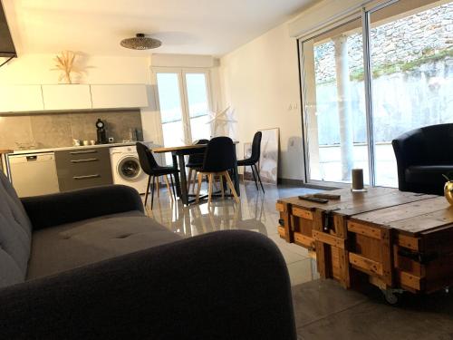 a living room with a couch and a table at Appartement tout confort avec terrasse in Reims