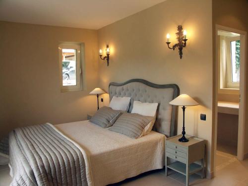 a bedroom with a large bed with two lamps and two tables at Château de Cachard in Boffres