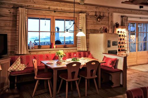 a dining room with a table and chairs and a refrigerator at Luxury Chalets Wiesenruh in Bichlbach