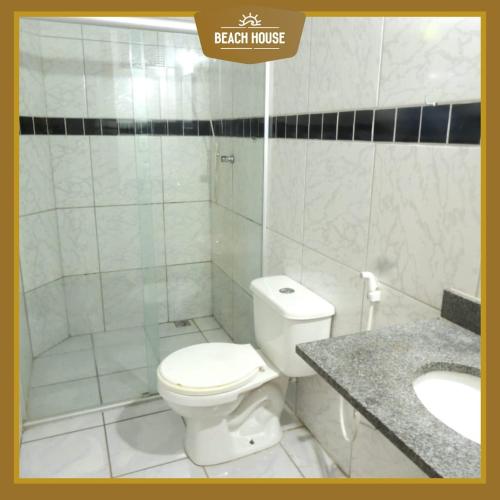 a bathroom with a white toilet and a sink at BEACH HOUSE l in Itacaré