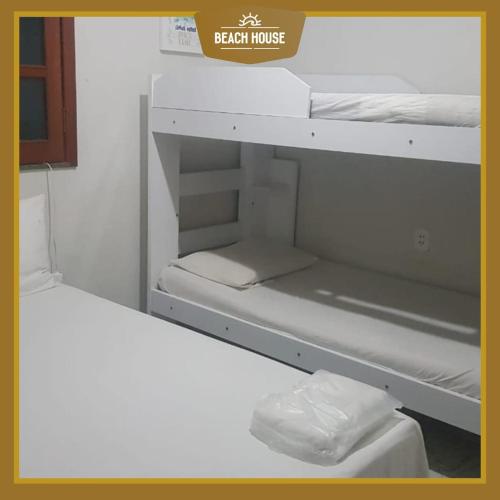 a room with two bunk beds and a sign that reads brain house at BEACH HOUSE l in Itacaré