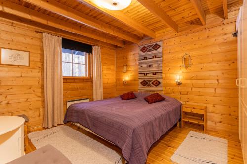 a bedroom with a bed in a log cabin at Villa Struka in Pyhtaa