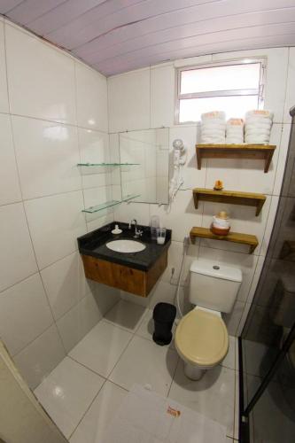 a white bathroom with a sink and a toilet at Pousada da Leide in Fernando de Noronha