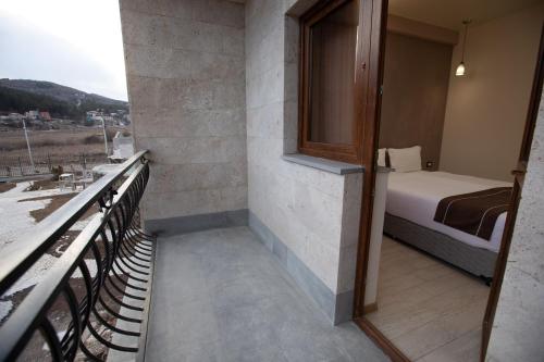 a small room with a bed and a balcony at Alaska Resort in Tsaghkadzor