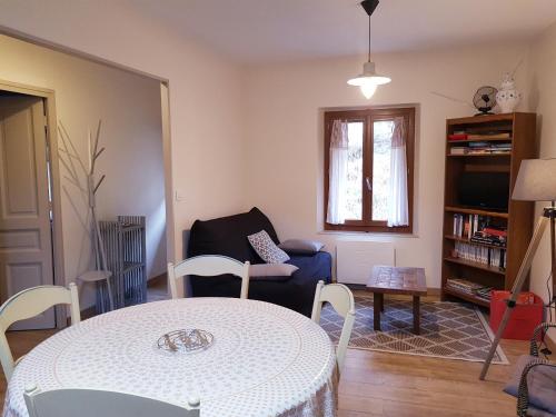 een woonkamer met een tafel en een stoel bij Agréable T2 avec petite cour privative in La Bourboule