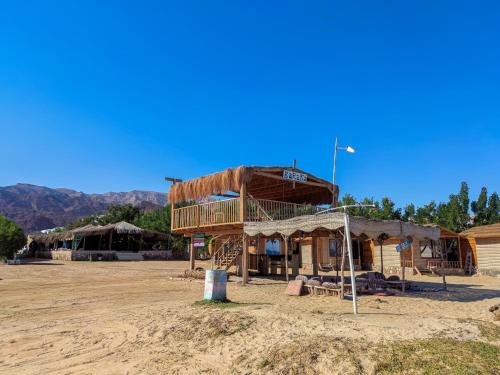 a building in the middle of a dirt field at Baraka Camp in Taba
