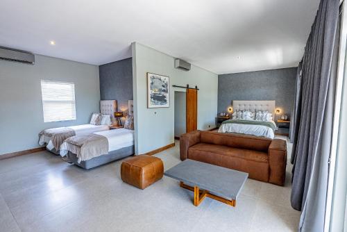 um quarto de hotel com duas camas e um sofá em Beach Wood Boutique Hotel & Resort em Ballito
