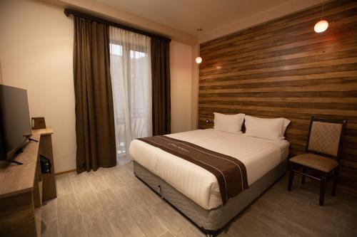 a bedroom with a bed and a wooden wall at Alaska Resort in Tsaghkadzor