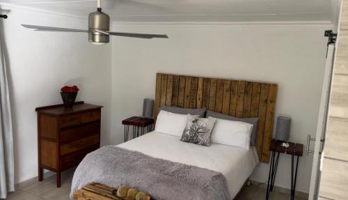 Schlafzimmer mit einem Bett mit einem Kopfteil aus Holz in der Unterkunft Pan's Breeze Overnight Accommodation in Dalmada