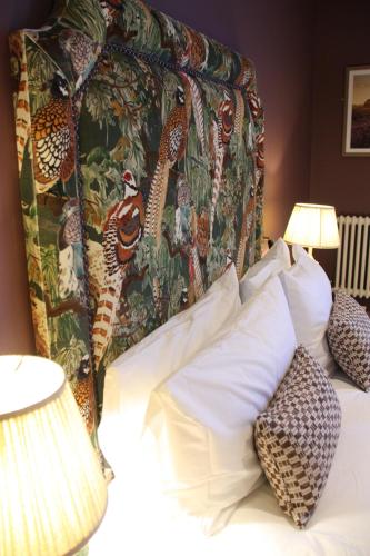 a bedroom with a bed with a colorful head board at The Bell Hotel, Saxmundham in Saxmundham