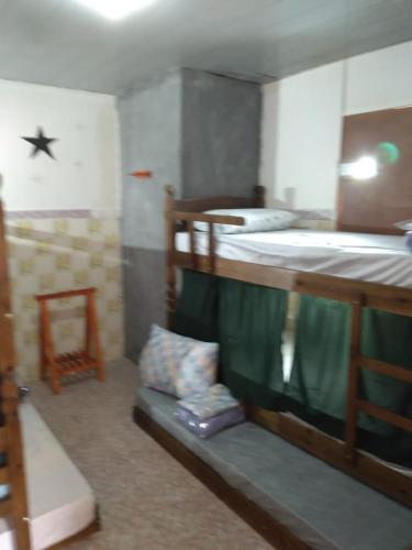 a room with a bunk bed with a couch under it at Poços Hostel in Poços de Caldas