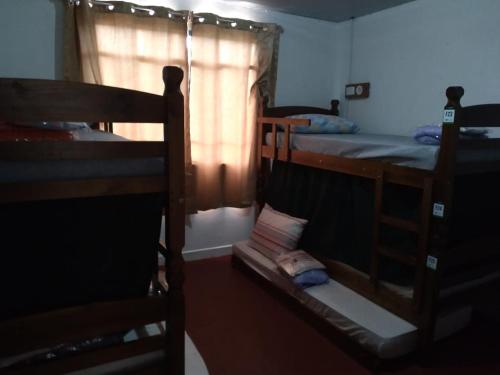 a room with two bunk beds and a window at Poços Hostel in Poços de Caldas