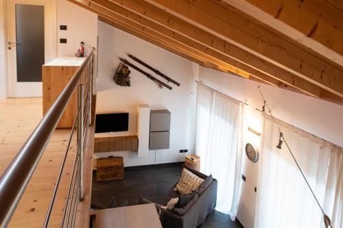 an attic room with a staircase and a living room at Relax in Pineta in Caldonazzo