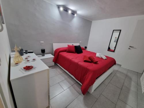 een slaapkamer met een rood bed in een witte kamer bij LamaisondeMaria in Carpinone