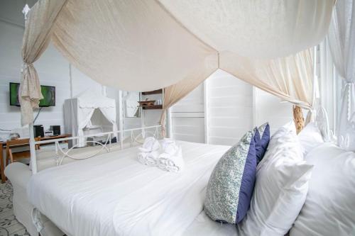 a bedroom with a white bed with a canopy at Proud Phu Fah Maerim Resort in Mae Rim