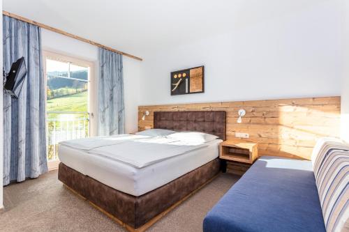 a bedroom with a large bed and a window at Eberharthof in Saalbach-Hinterglemm