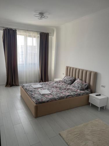 1 dormitorio con cama y ventana en City View Apartment, en Constanţa