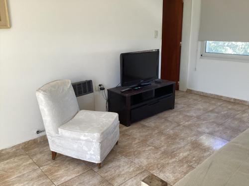 salon z krzesłem i telewizorem w obiekcie Altillo w mieście Alta Gracia