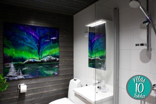 ein Bad mit einem WC und einem Wandgemälde in der Unterkunft Yllästokka 10 in Ylläsjärvi