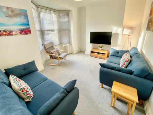 uma sala de estar com dois sofás azuis e uma televisão em Park View em York