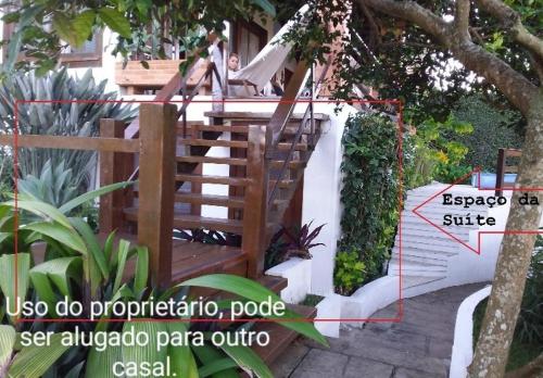 a wooden staircase leading up to a house at 3Suítes, piscina e vista do mar em condomínio pé na areia - pátio compartilhado in Búzios