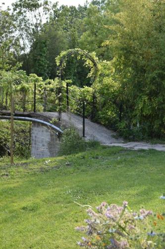 un jardin avec un pont et un chemin de randonnée dans l'établissement ONEIRO NISOS, à Maillé