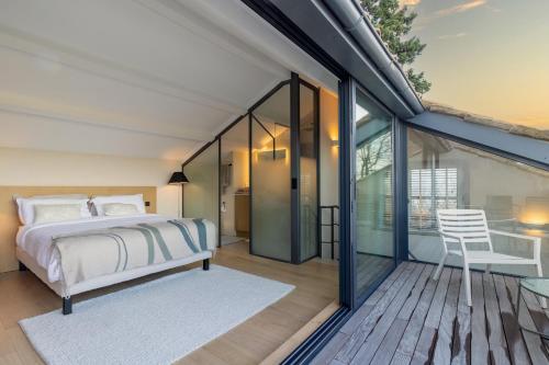 um quarto com uma cama e uma varanda em Mougins Collection - Magnifique maison au Cœur du Vieux Village de Mougins, vue sur les Alpes du Sud em Mougins