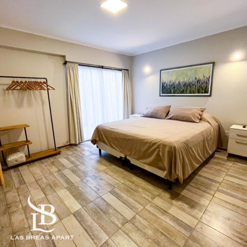 Un dormitorio con una cama y una ventana grande. en Las Breas Apart, en San Juan