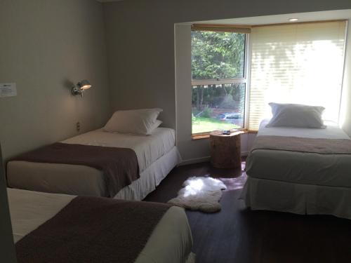 a bedroom with two beds and a window at Hotel Robledal in Las Trancas