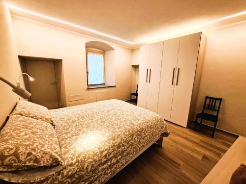 een slaapkamer met een bed, een raam en een stoel bij Casa Alpina- Praetoria Suite in Aosta