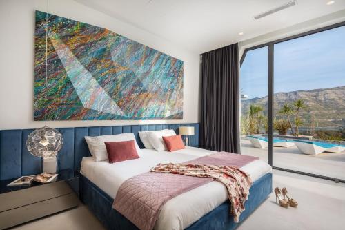 ein Schlafzimmer mit einem Bett und einem großen Wandgemälde in der Unterkunft Luxury Villa Korcula Diamond in Žrnovo