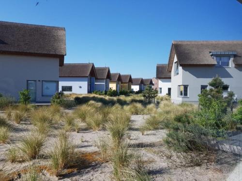 eine Reihe von Häusern am Strand in der Unterkunft Ostsee - Reetdachhaus Nr 2 "SÜDSTRANDHUS" im Strand Resort in Heiligenhafen