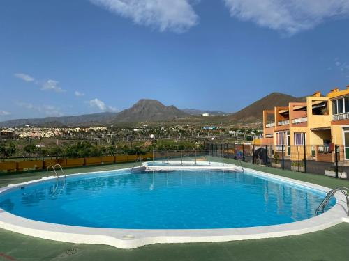 a large blue swimming pool on top of a building at Simon beach house Los Cristianos in Los Cristianos