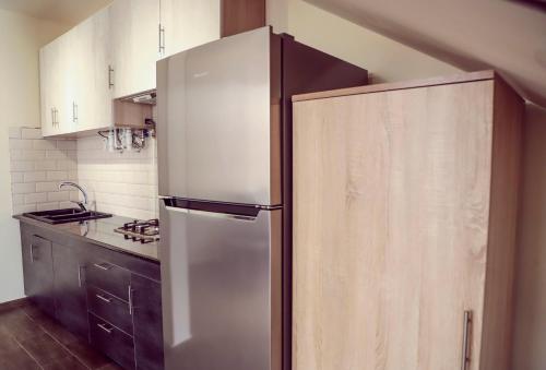 a kitchen with a white refrigerator and wooden cabinets at Alaska Resort in Tsaghkadzor