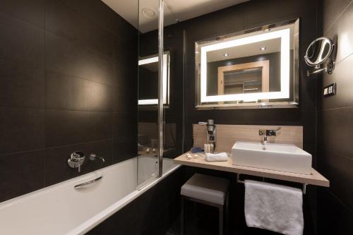 a bathroom with a sink and a mirror at Occidental Praha Five in Prague