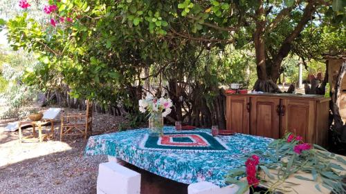 KASA BOUBAK في Kafountine: طاولة عليها قماش الطاولة الزرقاء والزهور