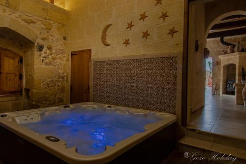 eine Whirlpool-Badewanne in einem Zimmer mit Sternen an der Wand in der Unterkunft Tan-Nanna Holiday Home in Xagħra