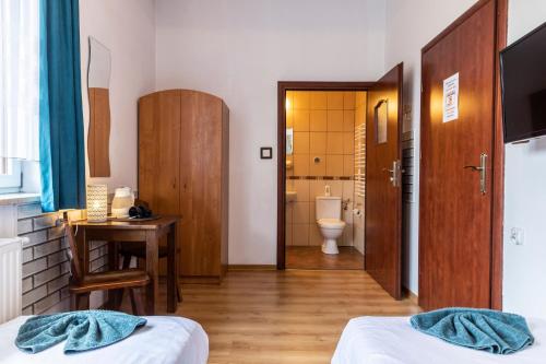 a room with two beds and a bathroom with a toilet at Brzoza w centrum Zakopanego in Zakopane